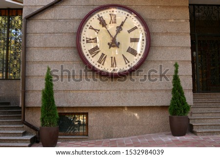 clock on the wall of a house on the street