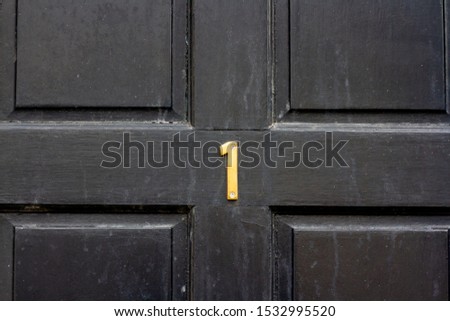 House number 1 on a black wooden front door