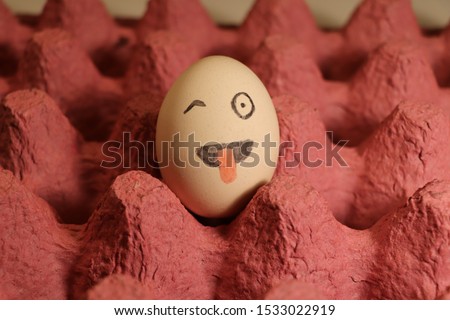 Drawing funny and cute face emoji on egg