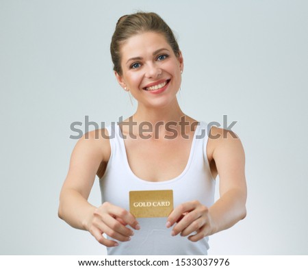 happy woman in white casual vest holding credit card in front of. isolated female portrait.
