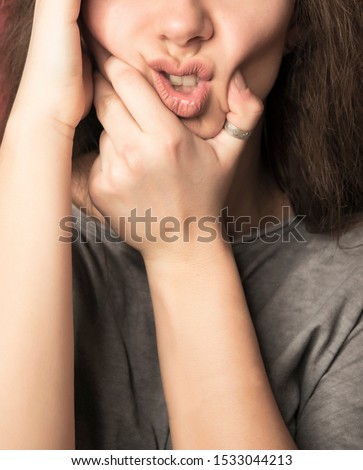 Beautiful brunette female making funny faces and posing in studio