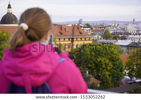 silhouette of a girl in focus on the background of the old city. brunette in a sports jacket travels and takes pictures of the city