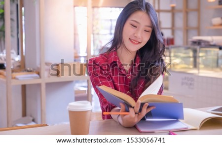 Beautiful Asian women with white skin, long hair sit reading books and smiling faces in the university library. out of focus. Emoji concept