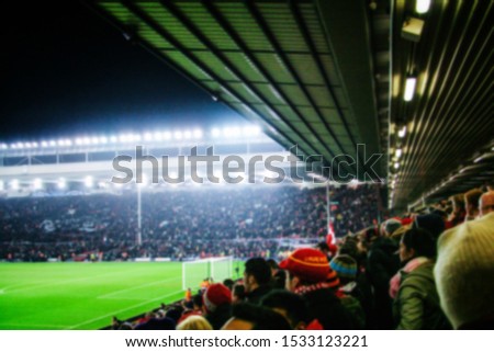 Blurred background of football players playing and soccer fans in match day on beautiful green field with sport light at the stadium. Sports,Athlete,People Concept.Mercy Side,Anfield,Liverpool.UK Royalty-Free Stock Photo #1533123221