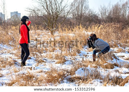 Two female friends taking photo in winter