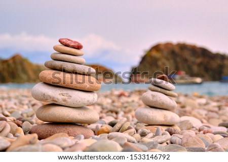 Stack of white pebbles stone against blue sea background for spa, balance, meditation and zen theme.
