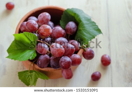 Vine and bunch of red grapes in a bowl. Beautiful red grapes ready for eating.
