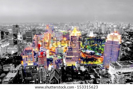 Image in black and white with selective color from the asian city of Bangkok , Thailand at nighttime when the tall skyscrapers are illuminated