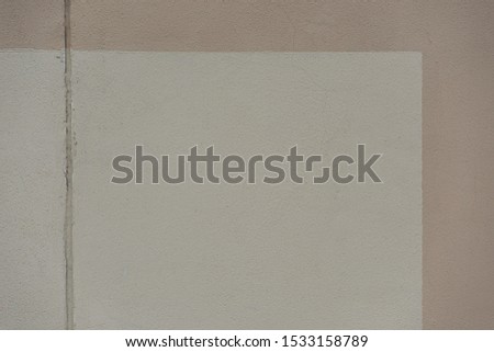 Smooth white and beige concrete wall surface with horizontal strip