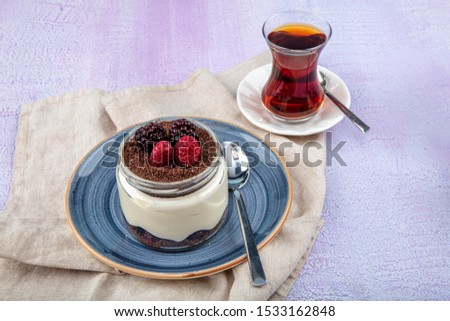 Magnolia Dessert . Blackberries and  Magnolia. Stewed magnolia dessert in glass cup on wooden background.