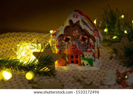 Christmas gingerbread house surrounded by Christmas trees and garlands.  Christmas Home Decoration
