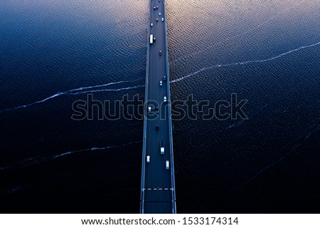 Aerial of Tasman bridge over wide flowing Derwent river in Tasmania Australia, with traffic, cars and trucks, crossing at sunset. Royalty-Free Stock Photo #1533174314