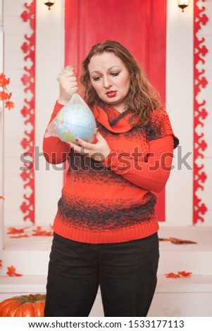 an emotional adult woman holds a planet in a plastic bag in her hands and shows irresponsible excessive consumer plastic