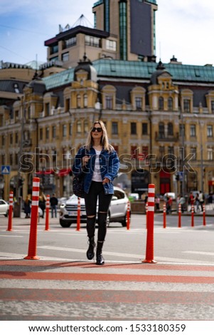 Young beautiful woman walks around the city in Europe, street photo, female posing in the city center