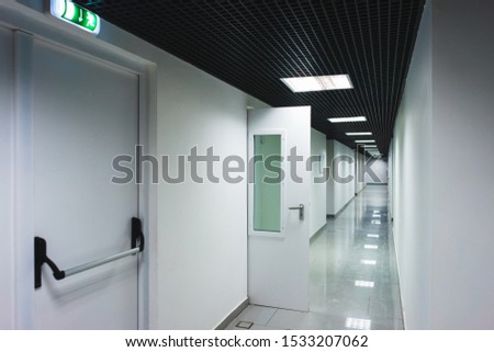 Interior internal corridor of modern office, industrial premises, laboratories or institutions. Corridor with light walls, black ceiling and shiny floor. Soft focus.