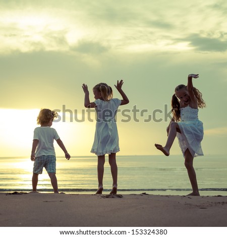 Happy children jumping on the beach on the dawn time