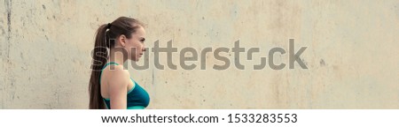 Attractive young woman holding violet yoga or fitness mat after working out. Panoramic image banner, toned.