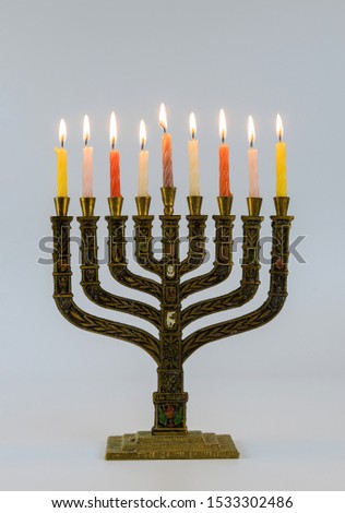 A symbolic candle lighting in the Jewish holiday of Hanukkah Menorah with lit candles in celebration of Chanukah on white background