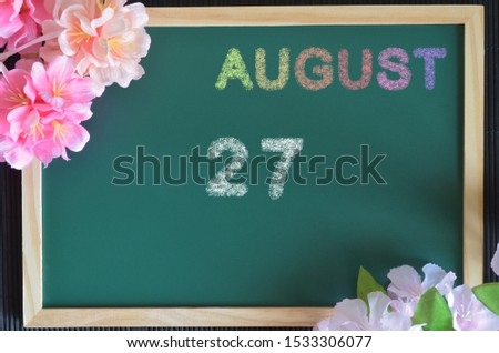 August month write with colorful chalk, flowers on the board, Date 27.