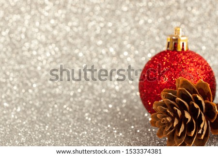Fir cone and Christmas tree toy red on a silver background. Open space for writing