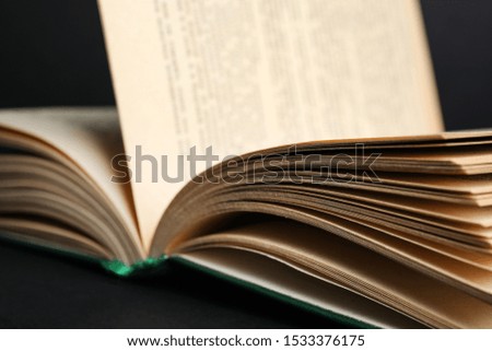 Closeup view of open book on black background