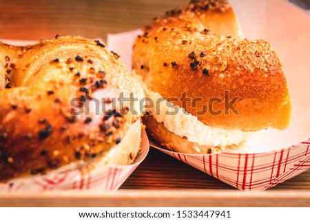 Freshly baked, crunchy typical NYC bagels with sesame, poppyseed topping, cream cheese spread and lox from coffee shop, cafe or bakery in Manhattan, New York City, close up with selective focus.