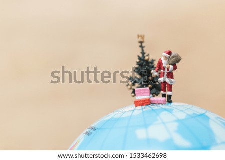 Miniature people : Santa Claus holding gift for kids , Merry christmas concept.