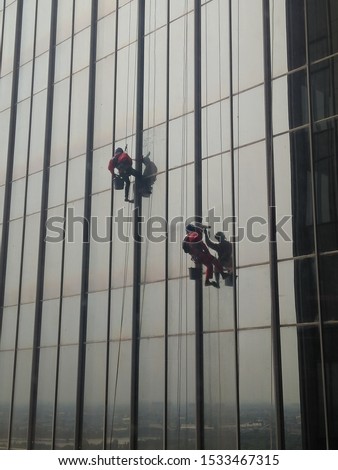 People work cleaning building windows or skyscrapper Royalty-Free Stock Photo #1533467315
