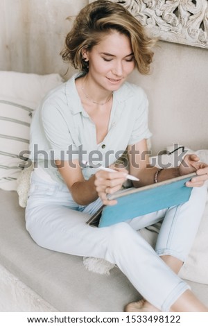 young beautiful girl draws on a graphics tablet, a girl with a tablet and pen