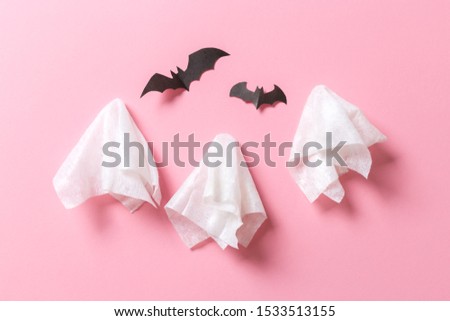 Top view of Halloween crafts, paper ghost on pink paper background with copy space for text. halloween concept.