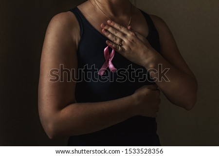October is breast cancer awareness month,a woman holds a pink ribbon to support people living and sick.Health, international women's day and the concept of the world day of fight against cancer.Noise Royalty-Free Stock Photo #1533528356