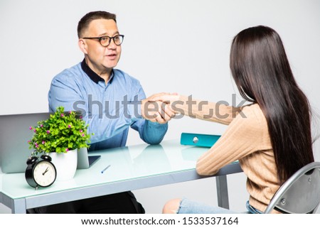 Therapist welcoming patient. Mature man therapist holding hand of young girl client greeting him into therapy room