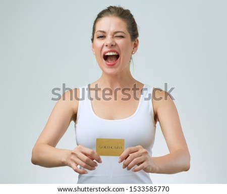 Smiling woman in white strap vest holding credit card in front of.  female portrait.