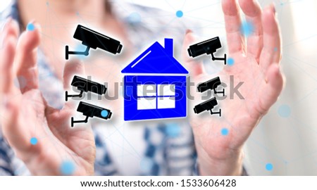 Security camera concept between hands of a woman in background