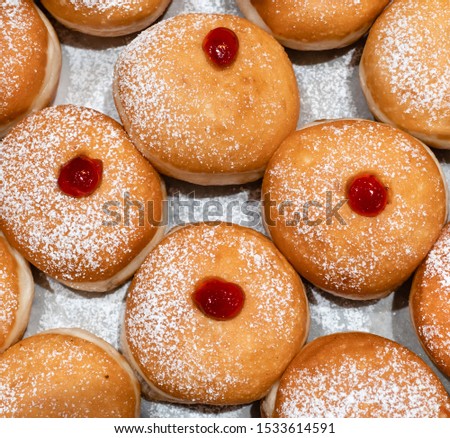 Fresh donuts  with jelly at the bakery display for Hanukkah celebration. Selective focus.