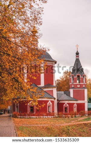 Church among autumn trees with orange foliage.Pereslavl Zalessky