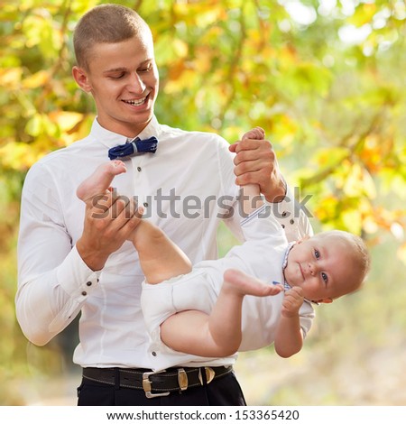Happy young man holding a smiling 7-9 months old baby 