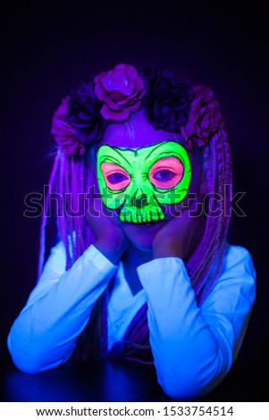 Light hair girl with African brides posing with neon face painting. Skeleton shape