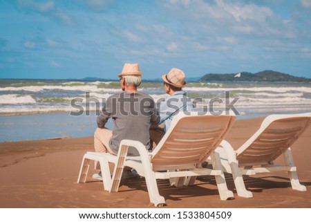 Romantic of senior couple sitting in deckchair on the beach together near sea.Love is everything,
Retirement age concept and love, copy space for text