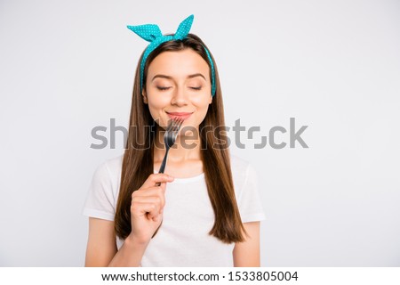 Portrait of inspired dreamy girl hold fork feel hungry want eat imagine tasty meal delicious burger close eyes wear stylish blue headband t-shirt isolated over white color background Royalty-Free Stock Photo #1533805004