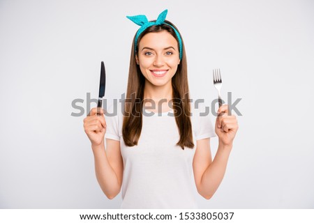 Close-up portrait of her she nice attractive lovely charming winsome cheerful cheery girl holding in hands fork knife crockery isolated over light white color background Royalty-Free Stock Photo #1533805037