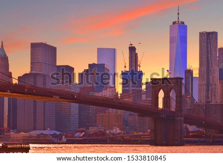 warm sunset on manhattan modern architecture skyline, brooklyn bridge with moody reflections on Hudson river, Manhattan New York city