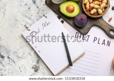 Notebook with diet plan and healthy products on white table