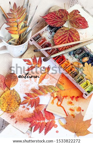 autumnal leaves, paper, watercolor paints and brushes. Autumn concept. symbol of fall season. atmosphere inspiration image.