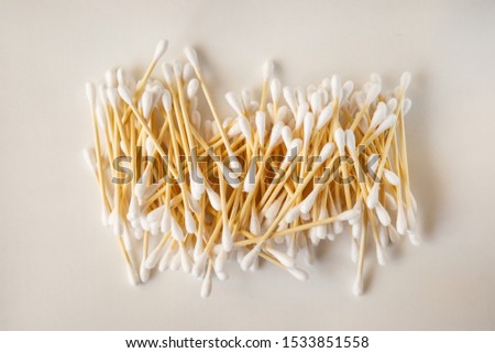 Bamboo cotton swabs or cotton buds are seen on warm white background