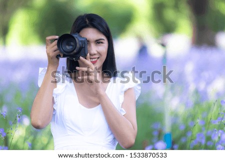 young woman photographer taking photo of blooming flowers, professional photographer.
