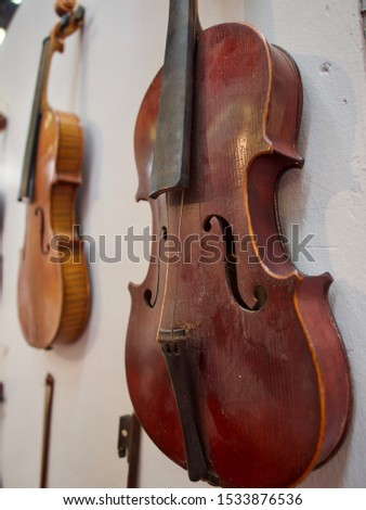 Background abstract art wooden violin placed on the wall background, very old model a bit destroyed vintage and artistic tone, classic style