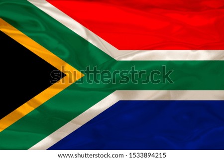 photo of the beautiful colored national flag of the state of South Africa on textured fabric, concept of tourism, economy and politics, closeup
