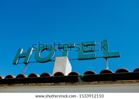Hotel sign in relief in the blue sky.
