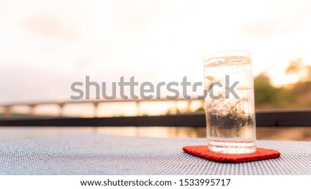 A glass of cold water on the table in the evening time.